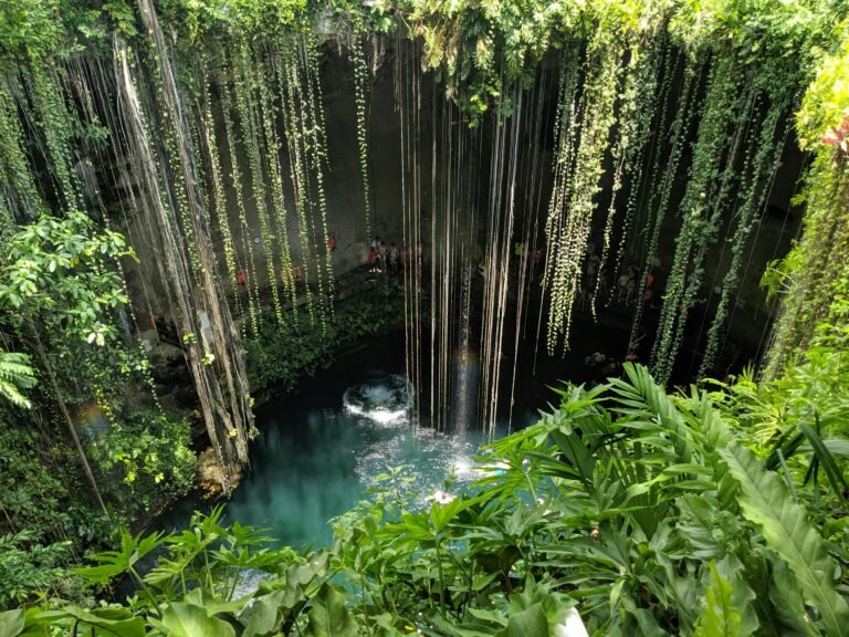 Cotizar servicios de translados 9 Beautiful view of Cenote Ik Kil surrounded by lush greenery in Yucatan, Mexico.