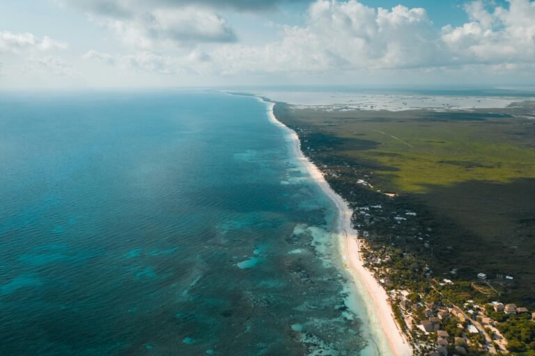 Cotizar servicios de translados 4 A breathtaking aerial panorama of Tulum's turquoise waters and lush coastline under a bright sky.